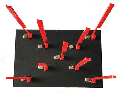 Two Tanka poems share same middle line to form an X shape and this image shows a view from above which emphasizes the X shape and also shows the audio buttons at base of acrylic cut poetry lines which when pressed read the poetry lines aloud.